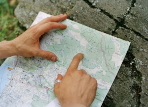 Man's hand pointing on street map